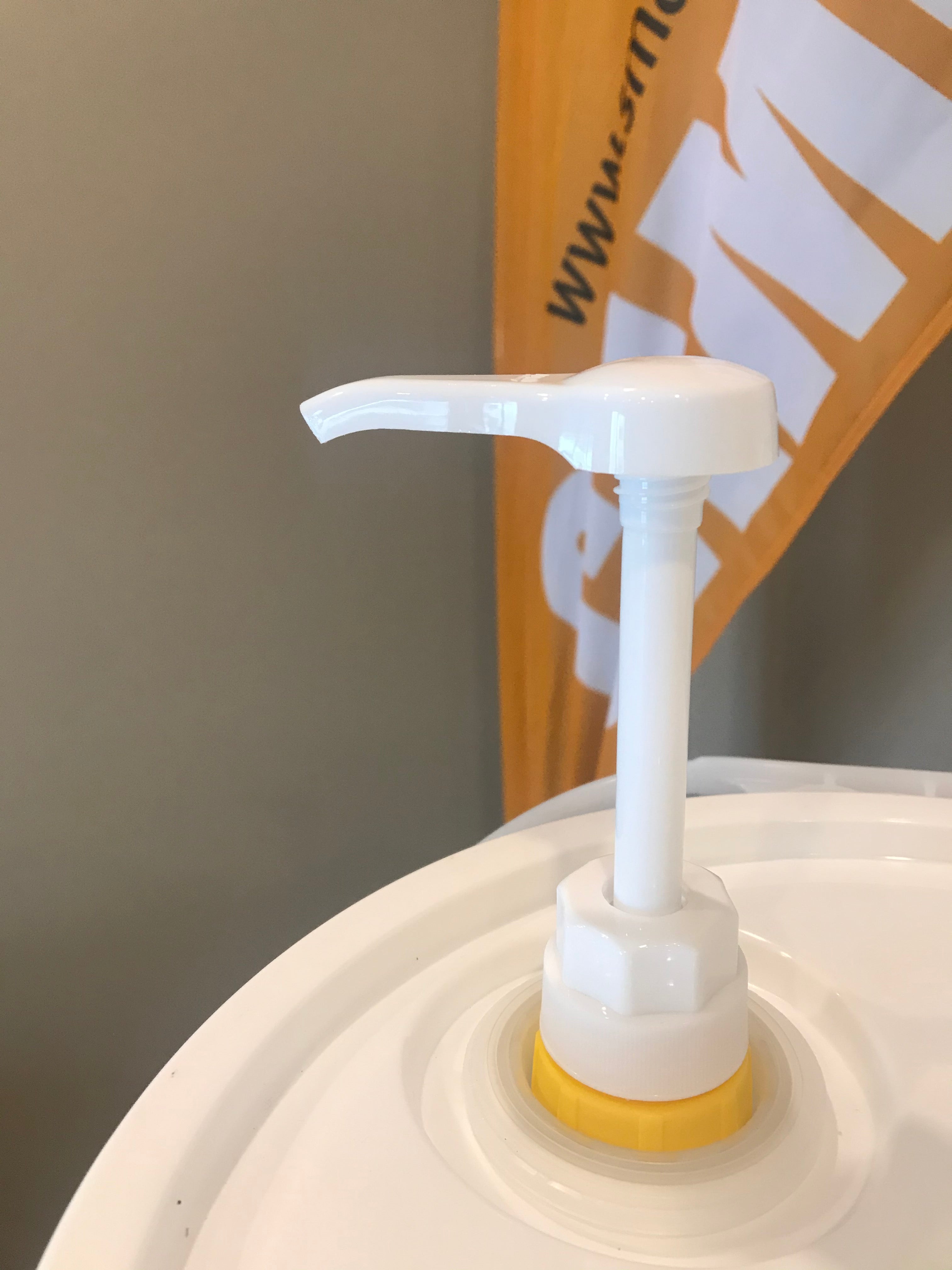 Smart Earth pail pump fitted into the lid adapter on a camelina oil pail