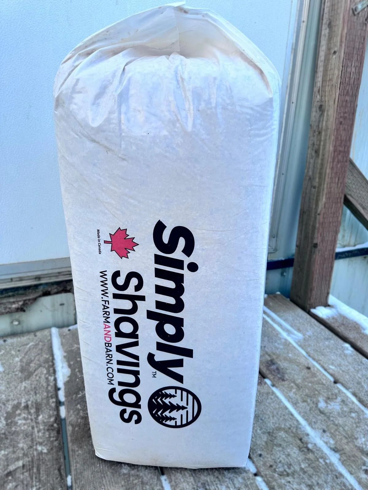 Opposite side of the Farm & Barn softwood shavings bag with the Simply Shavings logo