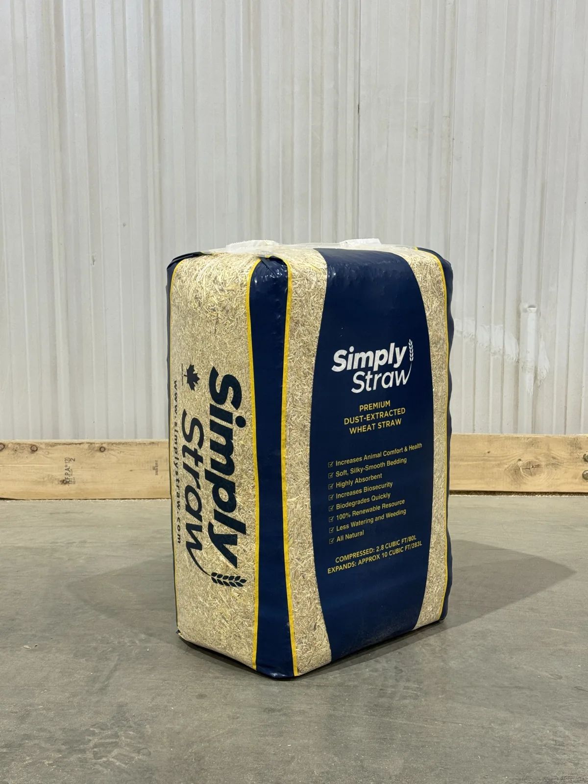 Simply Straw 80 L compressed wheat straw bale on a barn floor